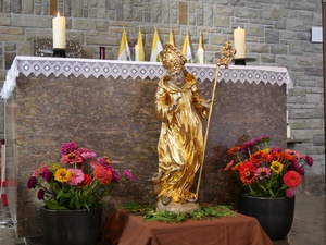 Eine goldene Figur steht auf dem Boden vor dem Altar der Kirche in Dipbach.